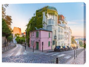 Cozy old street with pink house at the sunny sunrise, quarter Montmartre in Paris, France