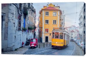 Old tram and tuk-tuk on a street in Lisbon.