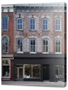 facade of old brick buildings with stores at street level and apartments above