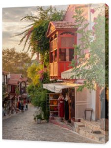 Piękna ulica na starym mieście Kas z butikami o zachodzie słońca w Turcji