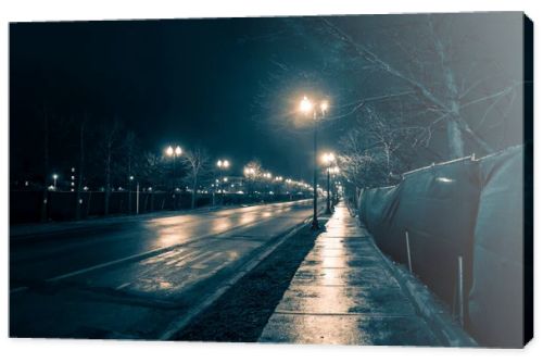 Empty dark and wet urban city street road after rain at night