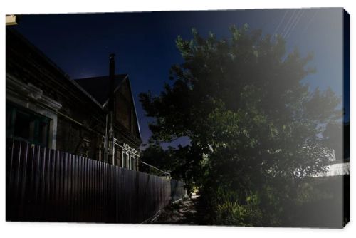 Full moon over quite village at night. Beautiful night landscape of old town street with lights. Russia