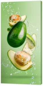 Fresh avocado cut into slices with water drops splash flying in the air and levitate on a mint green background. Healthy diet ingredient recipe. Trendy motion food composition. Creative fruit concept.