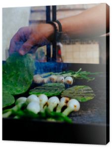 Man grilling fresh vegetables on barbecue in backyard