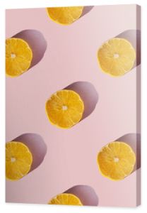 Uniform pattern of dried lemon slices with shadow on a pink background. Flat lay