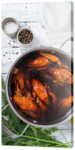 cooked crawfish in saucepan with lemons and spices on wooden background