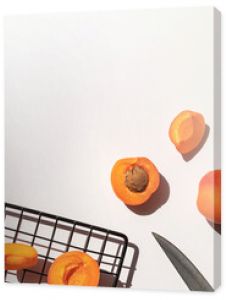 Organic ripe apricots under sun shadows on the white table top view