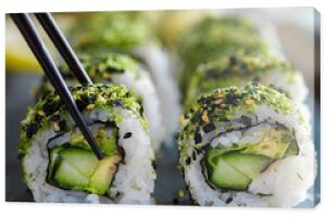 healthy kale and avocado sushi roll with chopsticks