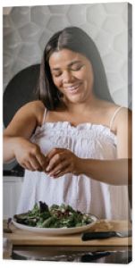 Young adult woman preparing salad for lunch in luxury kitchen