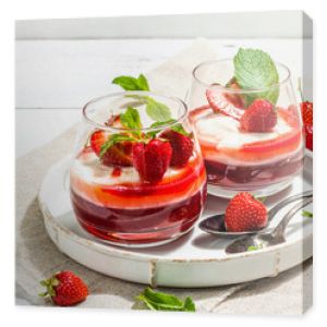 Italian dessert panna cotta in glass with strawberries. Healthy sweet food, hard light, dark shadow