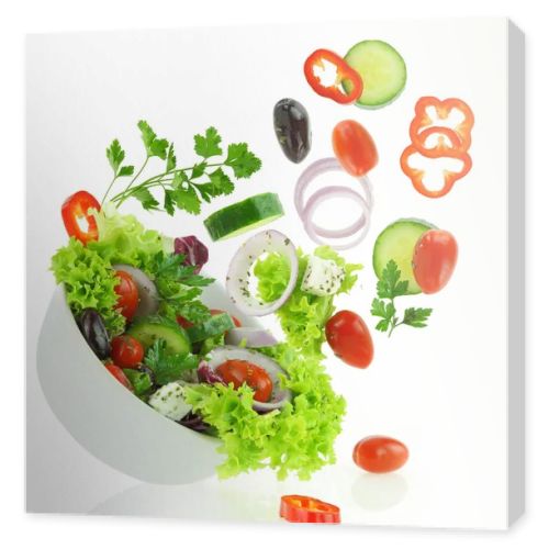 Fresh mixed vegetables falling into a bowl of salad