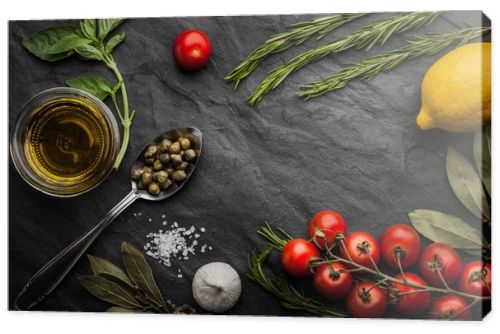 Herbs mix with tomatoes, lemon and olive oil on the black stone table