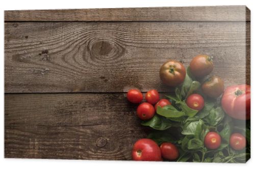 top view of tomatoes with spinach on wooden table 